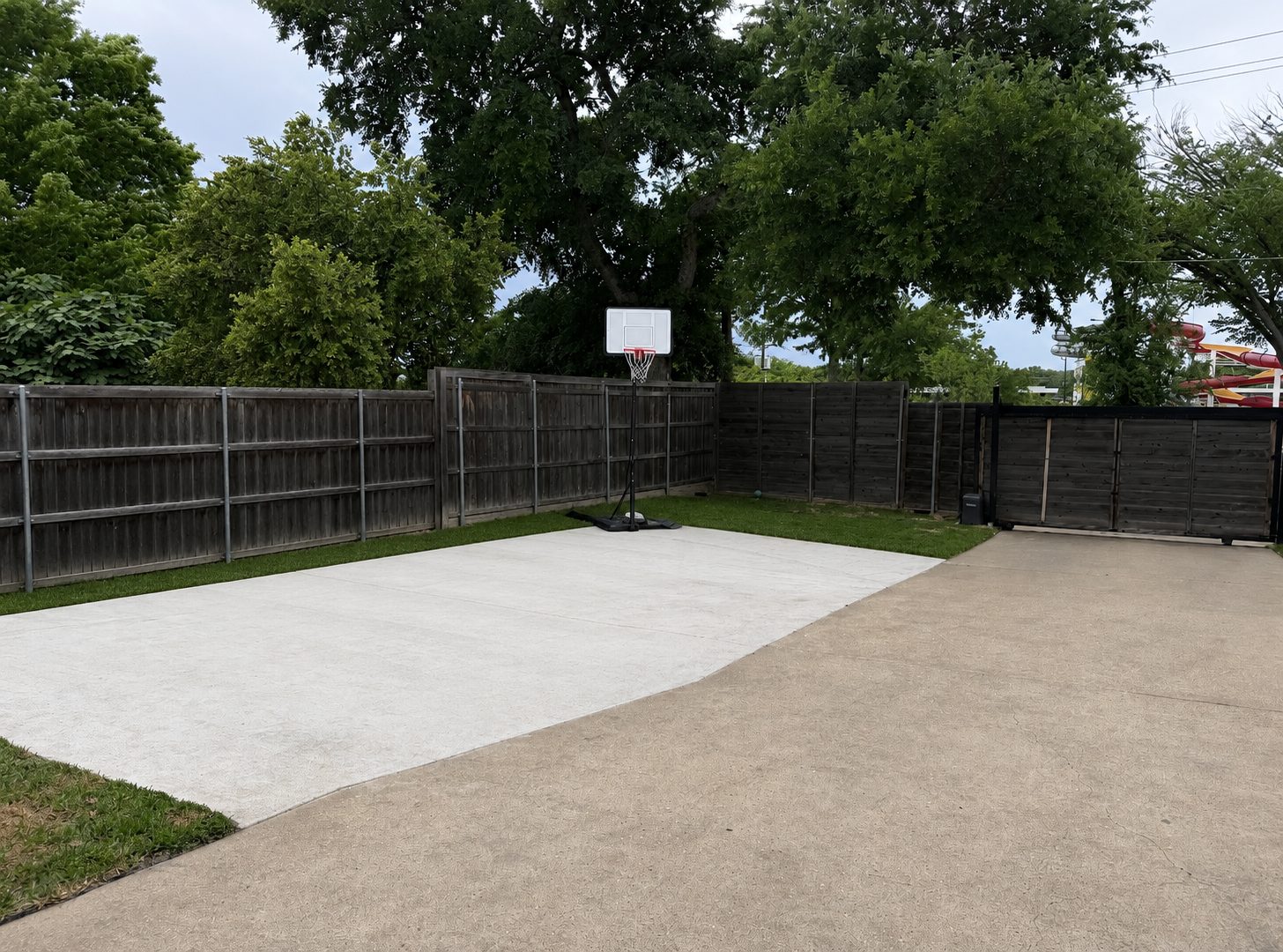 Backyard concrete sport court with basketball goal